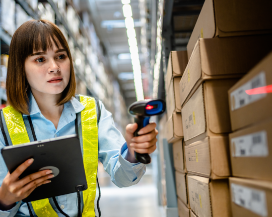 A person scanning boxes in a warehouse