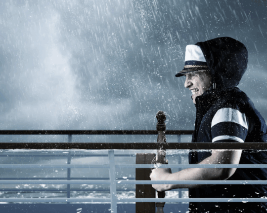 man steering ship through storm