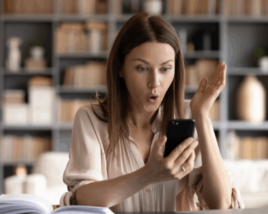 women excited by what shes looking at one her phone