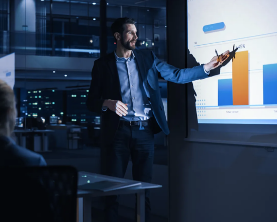 man looking at graph on projector