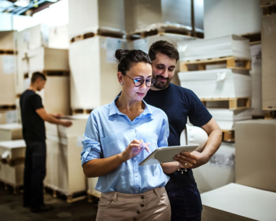 woman man looking at tablet in warehouse